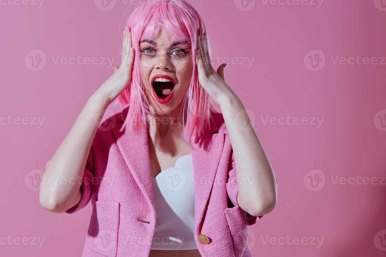 bella giovane femmina attraente Guarda rosa parrucca elegante Abiti colore sfondo inalterato foto