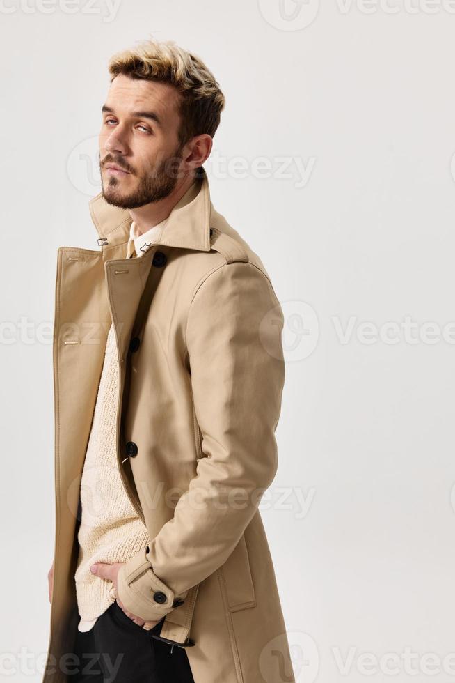 bello uomini nel beige cappotto modello maglione leggero sfondo foto