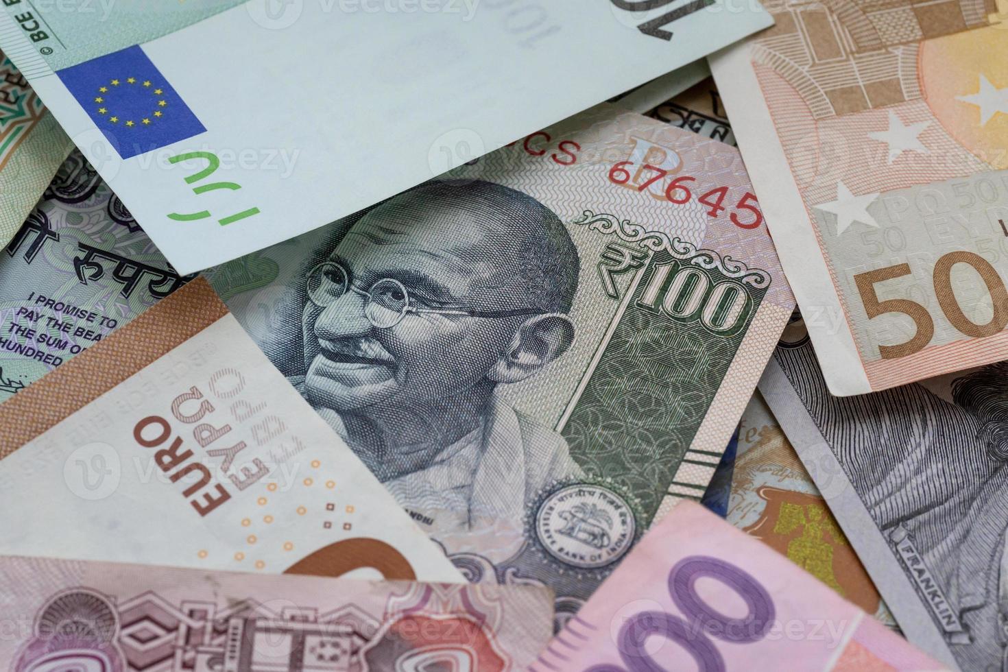 uno centinaio indiano rupie banconota tra Euro, dollari e altro valute foto