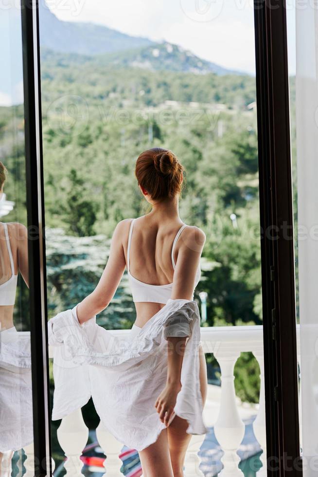 ritratto di giovane bellissimo donna nel sexy biancheria intima in posa su balcone rilassamento concetto foto