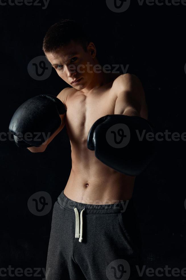 culturisti boxe guanti su nero sfondo e grigio pantaloni atleta foto