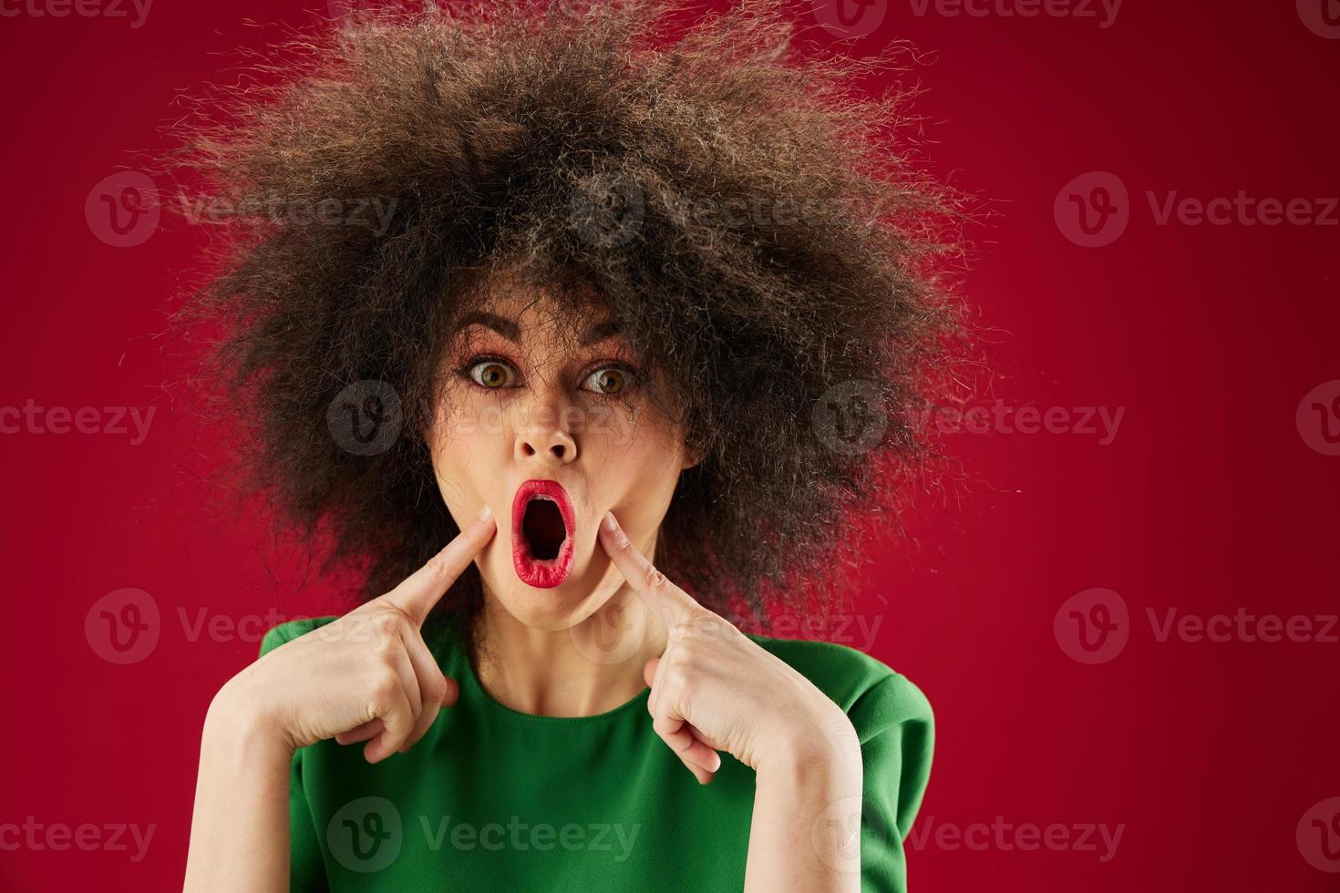 ritratto di un' affascinante signora smorfia afro acconciatura rosso labbra moda rosso sfondo inalterato foto