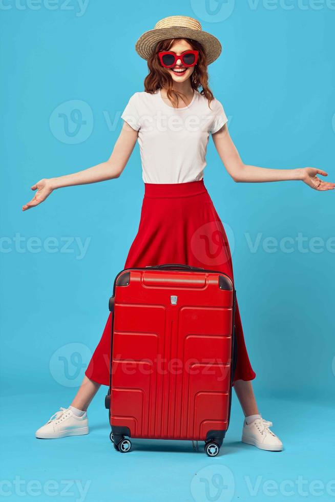 donna turista rosso valigia vacanza divertimento occhiali da sole viaggio foto