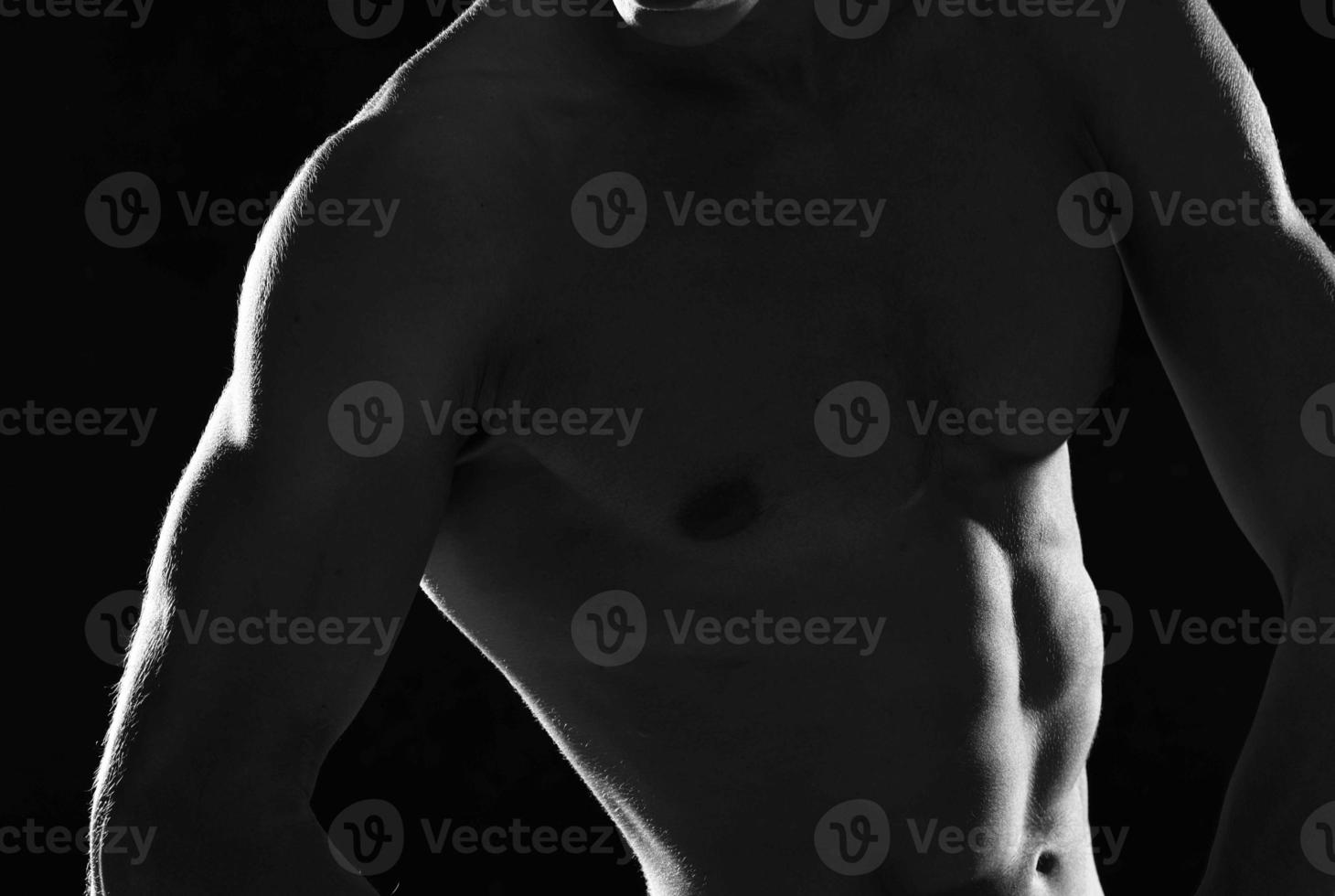sportivo muscolare uomo nel nero pantaloncini bodybuilder buio sfondo foto