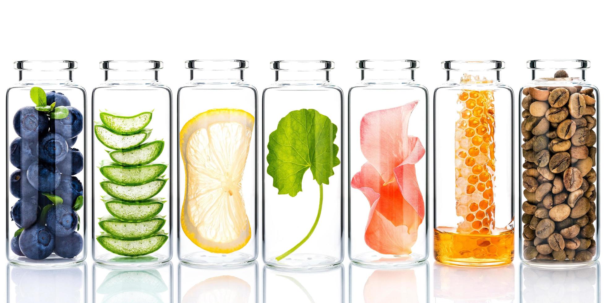 cura della pelle fatta in casa con ingredienti naturali ed erbe in bottiglie di vetro isolato su uno sfondo bianco foto