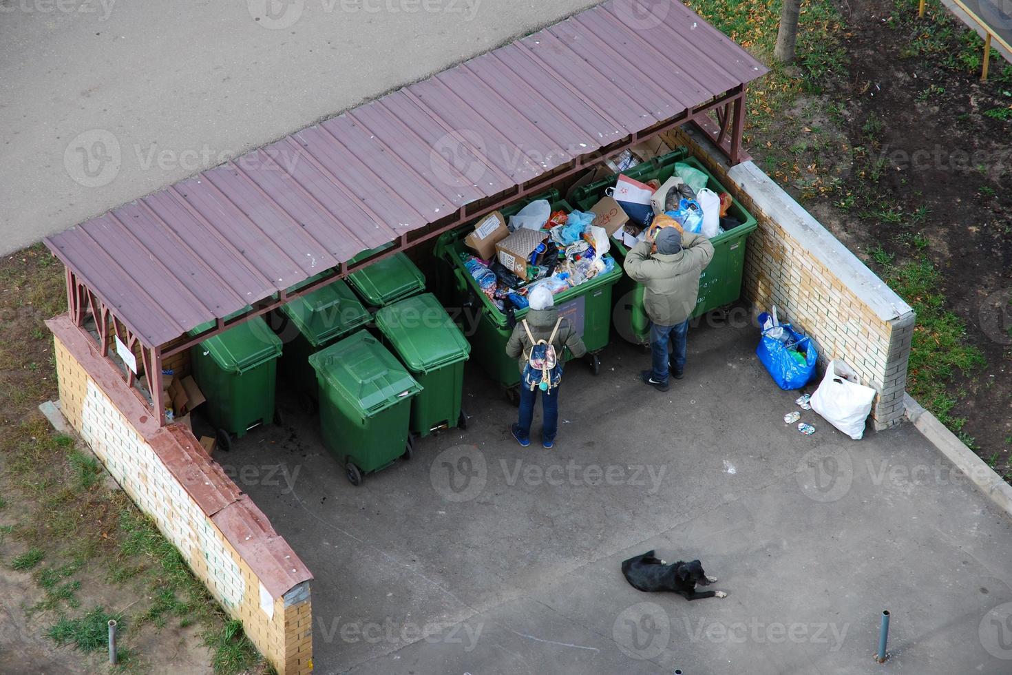 persone scavando nel cassonetti e alimentazione loro cane, Mosca, 28.10.2019 foto