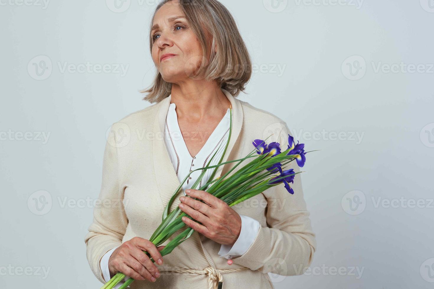 anziano donna nel un' condimento toga con un' mazzo di fiori memoria cura foto