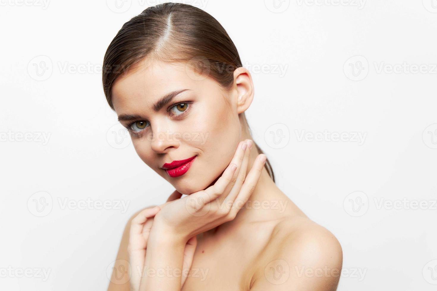 donna con fiore mantiene un' mano su il collo pulito pelle cura luminosa trucco foto
