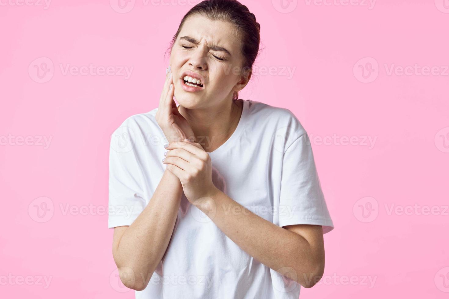 donna nel bianca maglietta Tenere sua collo dolore i problemi rosa sfondo foto