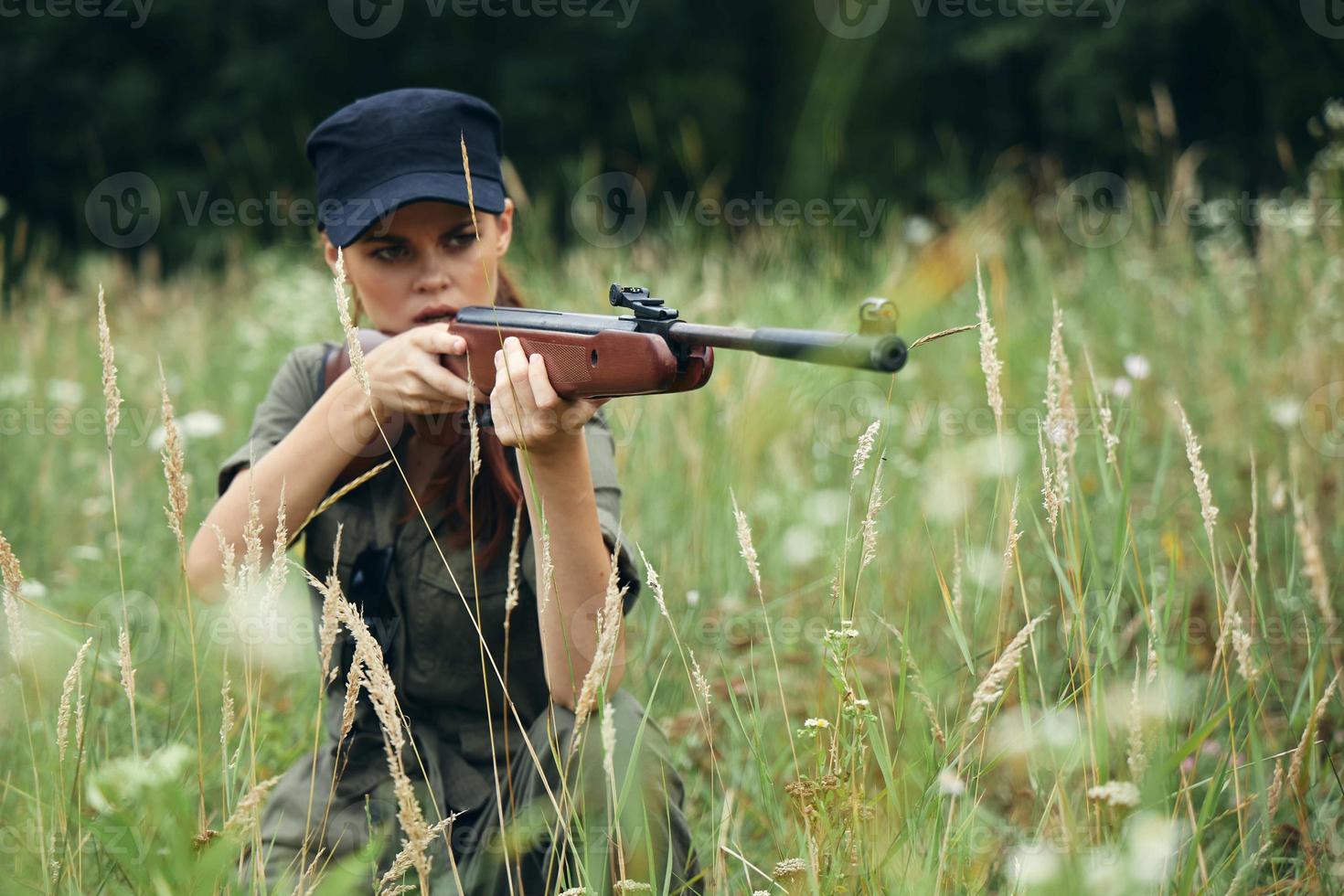 donna su natura un' riparo con un' arma sembra in il scopo verde le foglie foto