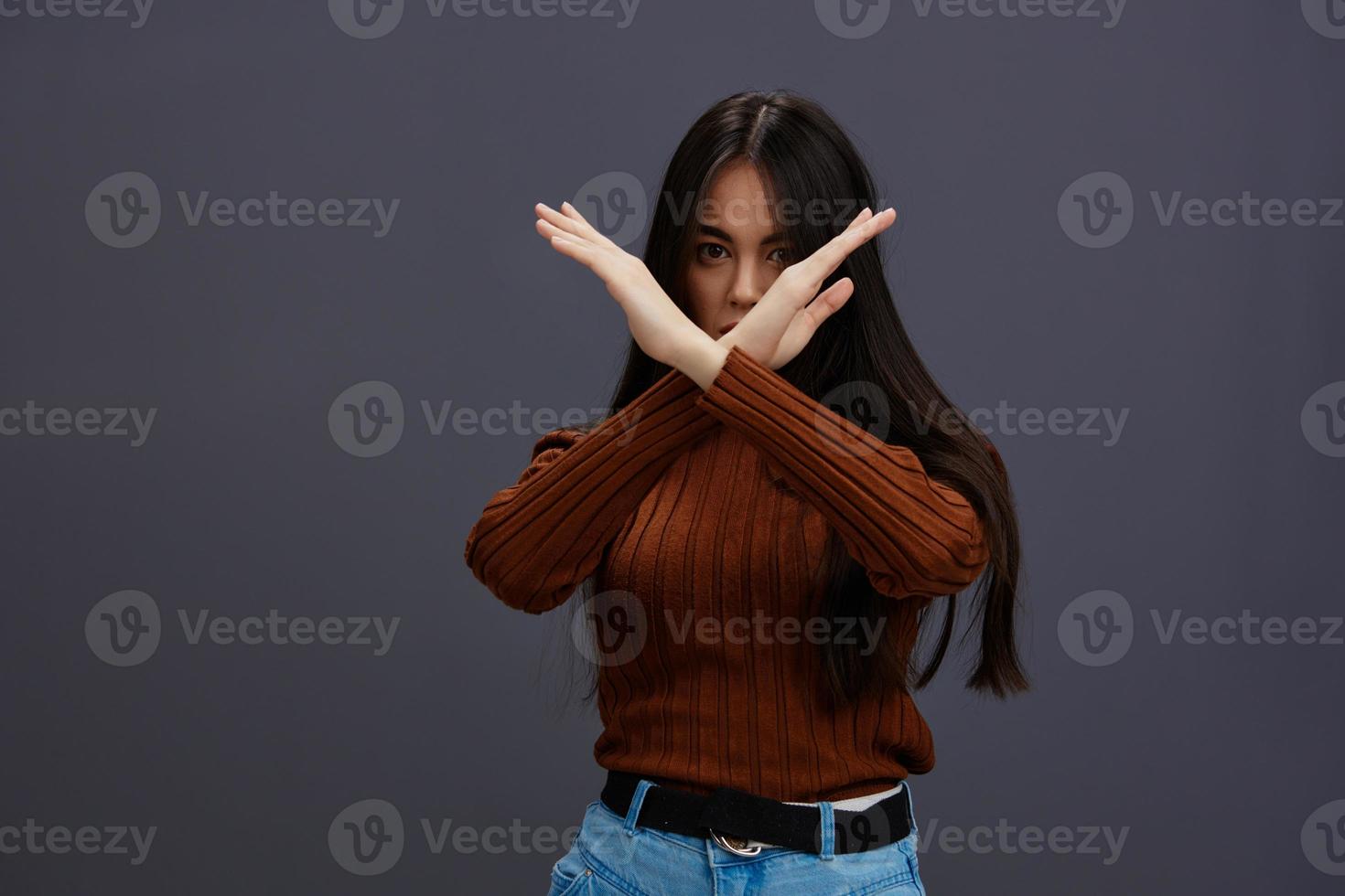 bellissimo donna mano gesti Marrone maglione moda grigio sfondo foto