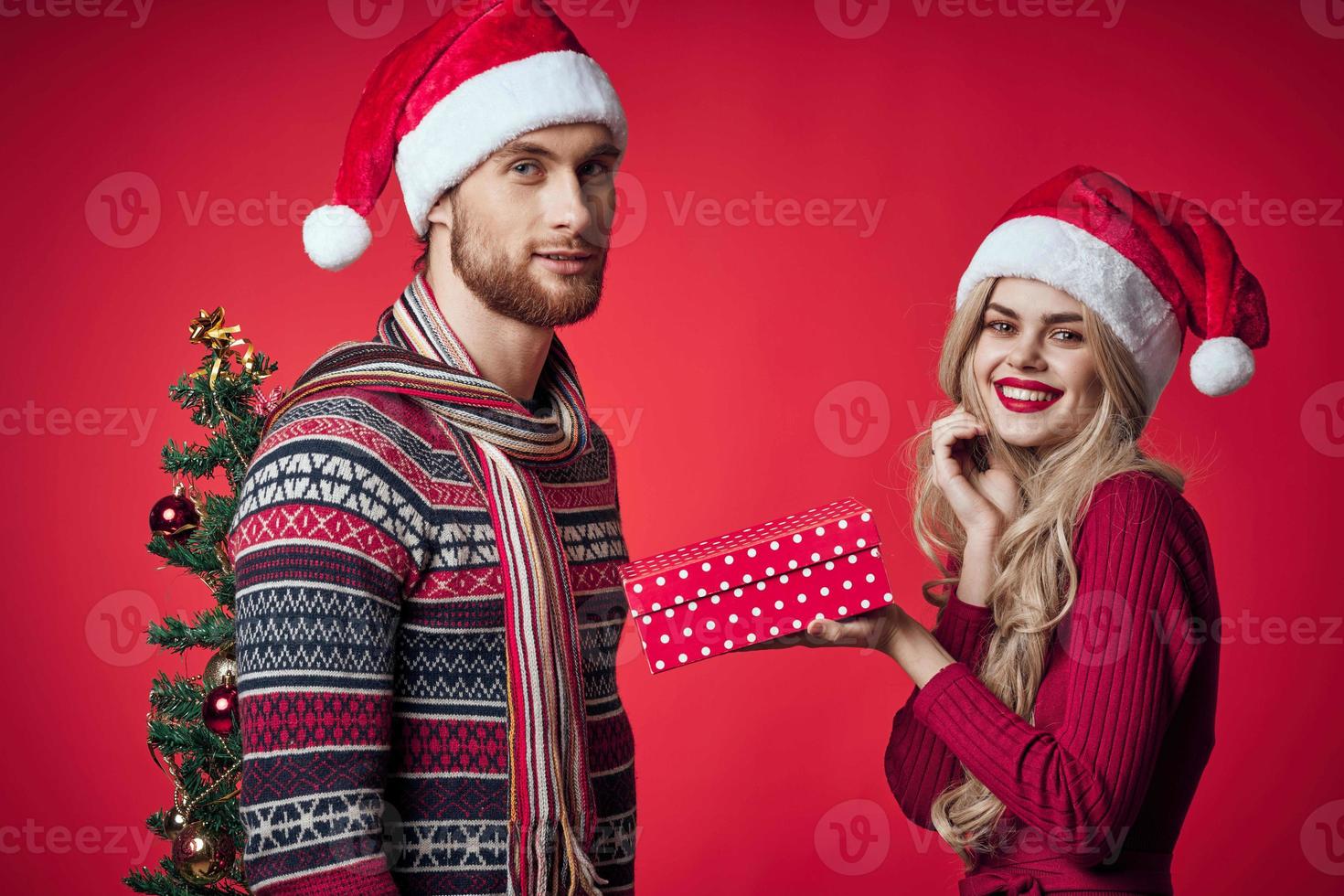 giovane coppia Natale decorazioni vacanza in posa rosso sfondo foto