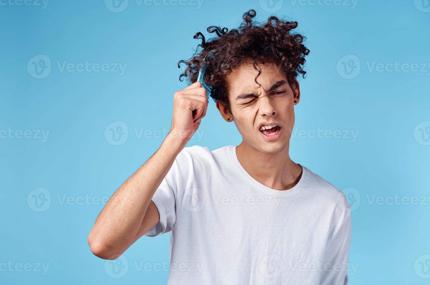 bello tipo con Riccio capelli su un' blu sfondo ritratto avvicinamento ingarbugliato riccioli foto