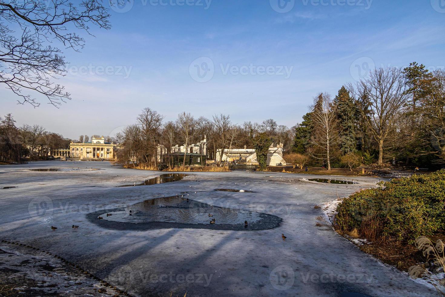 paesaggio con un' palazzo su il acqua nel varsavia, Polonia presto primavera su un' soleggiato giorno con fusione neve foto