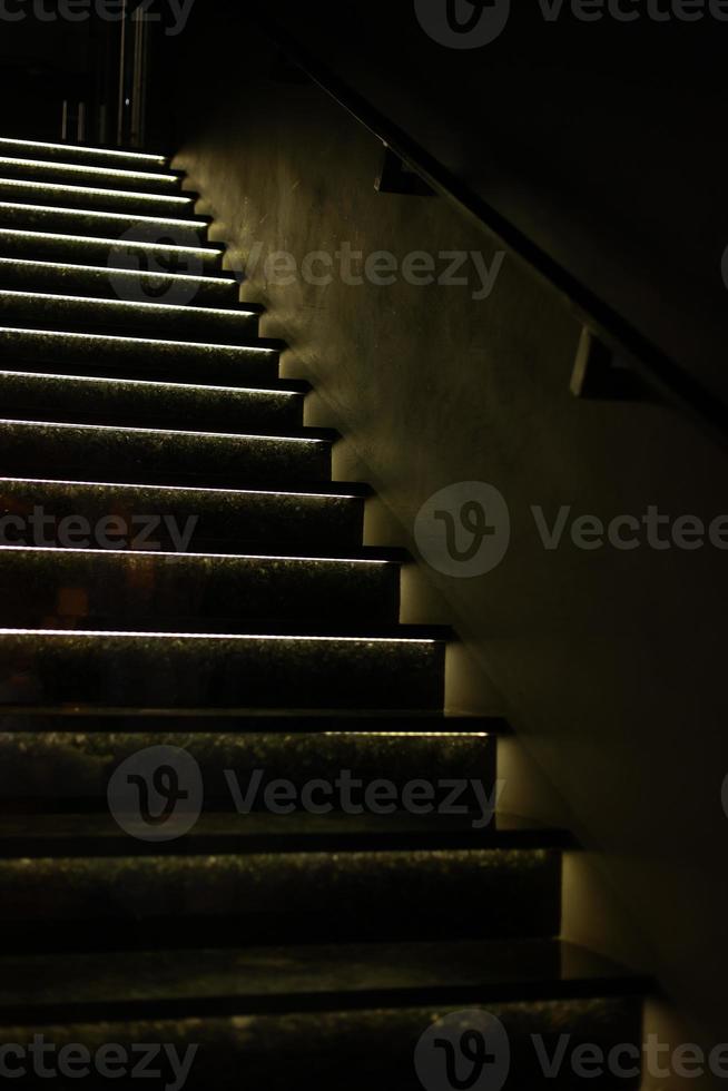 tromba delle scale, emergenza Uscita nel un' bloccare di appartamenti. interno scala, fuoco fuga, contro grigio calcestruzzo muri su e giù con naturale luce del sole a partire dal porta al piano superiore. foto