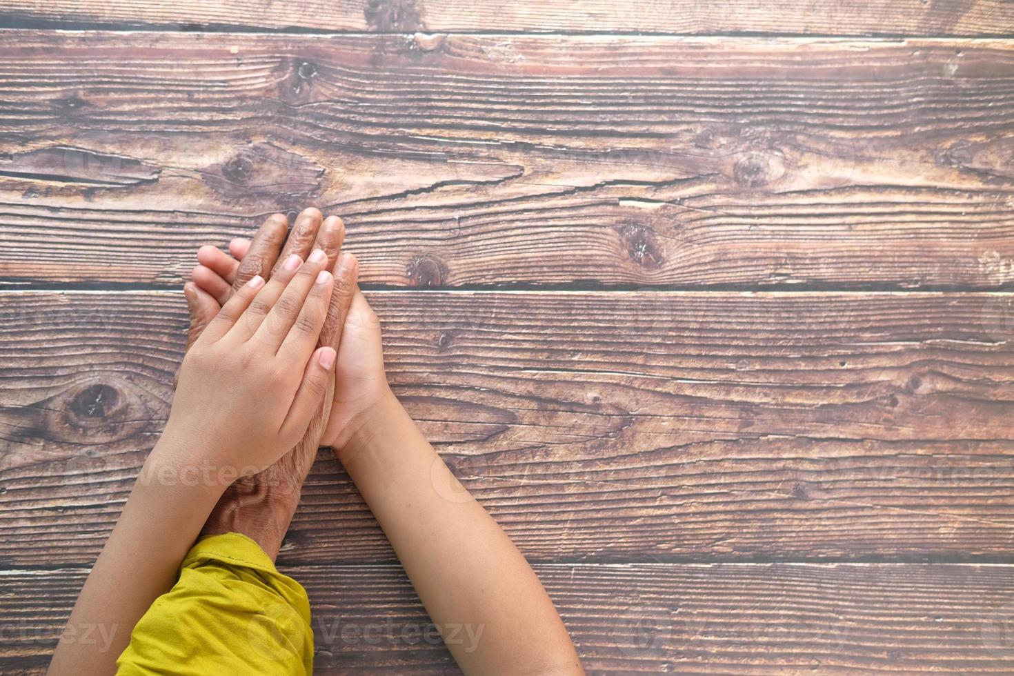 bambino che tiene la mano della donna maggiore foto