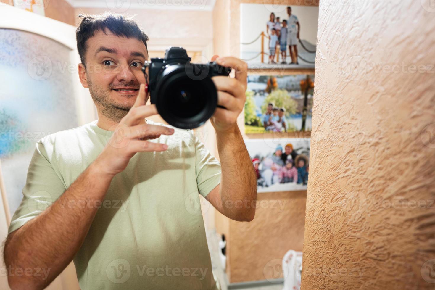 divertente uomo fotografo fabbricazione autoscatto con telecamera nel specchio a casa. foto