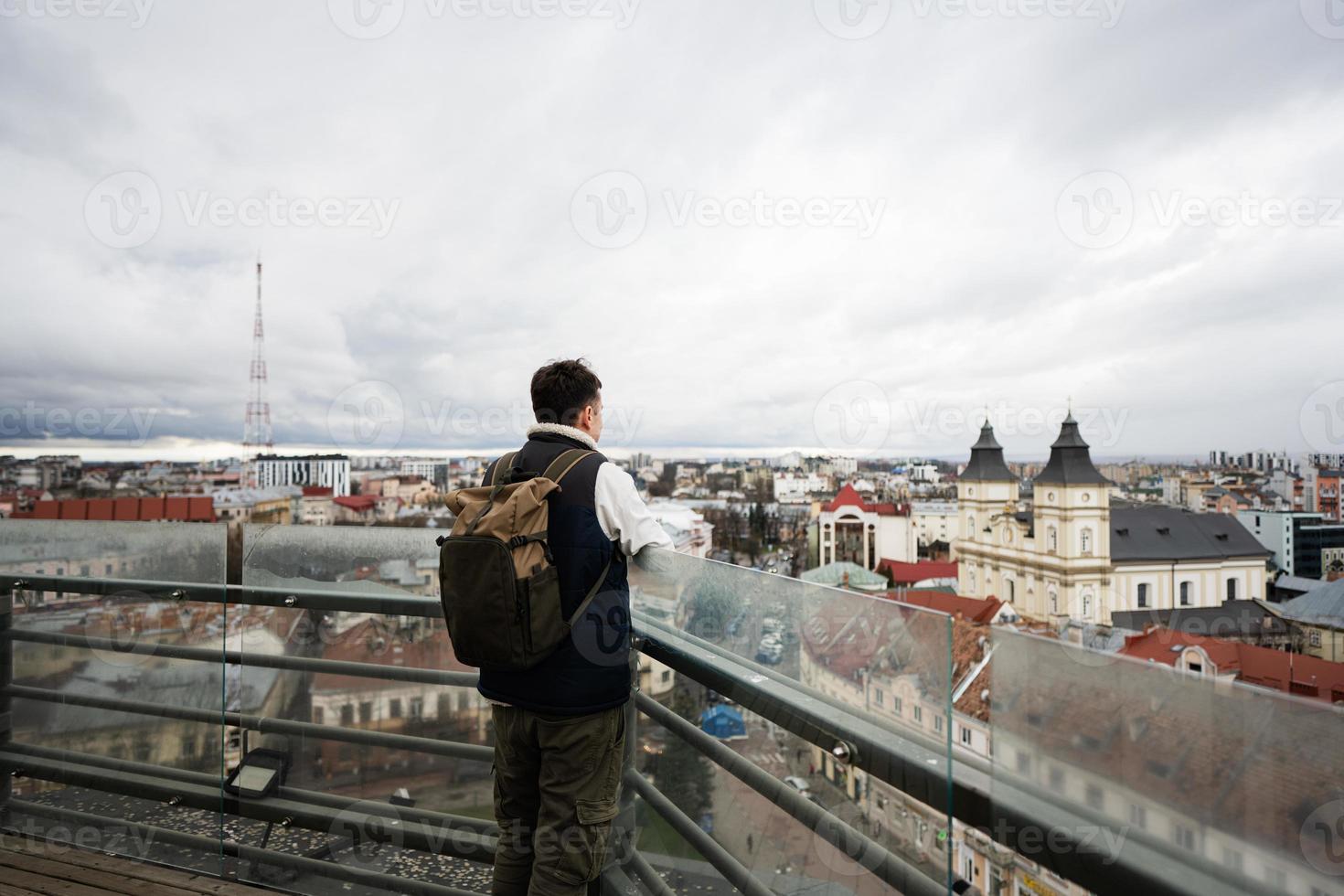 indietro Visualizza di uomo turista con zaino In piedi su sfondo di panorama Visualizza città. foto