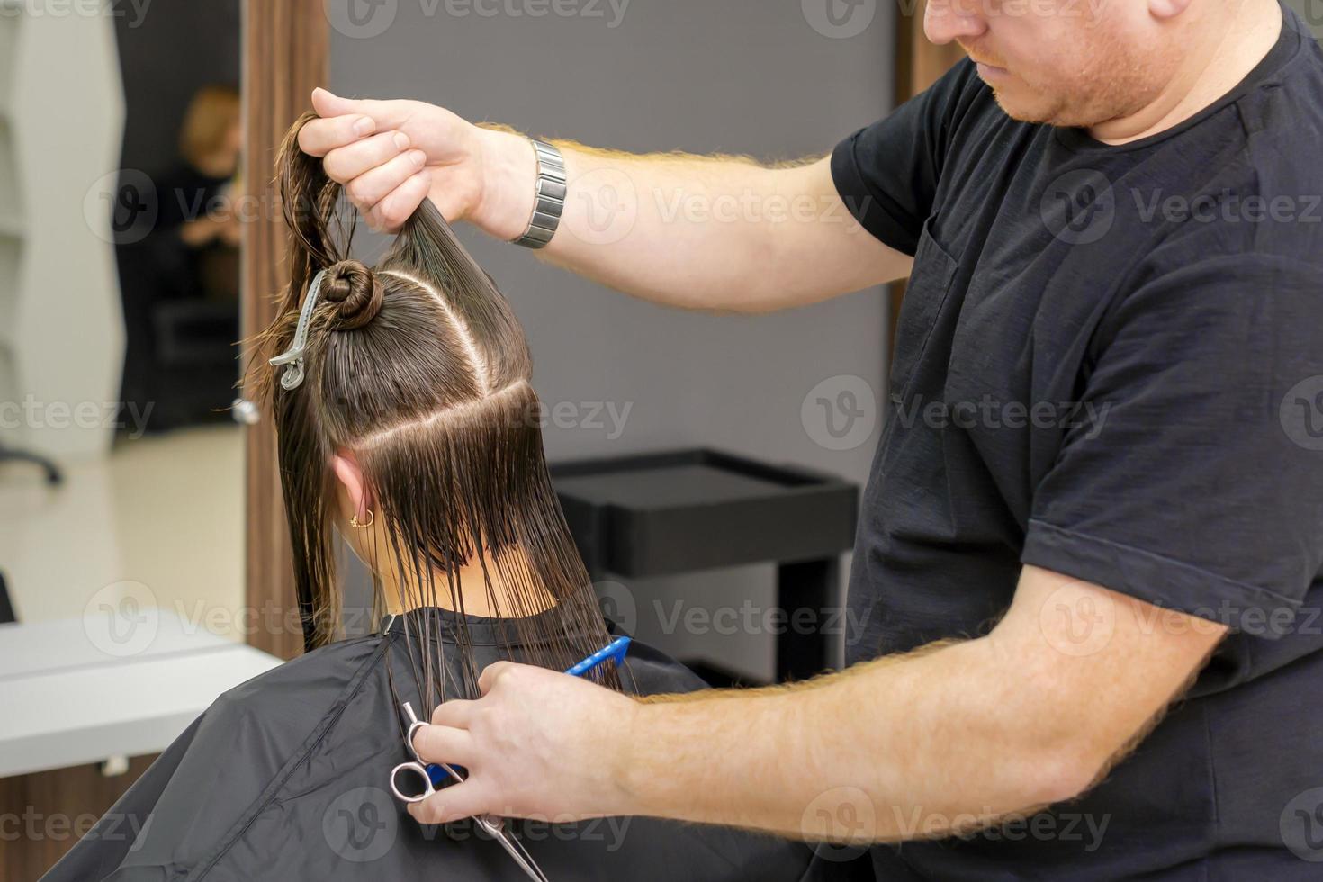 maschio parrucchiere si divide lungo capelli foto