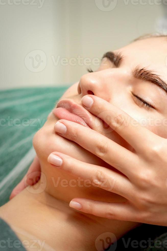 giovane donna ricevente facciale massaggio foto