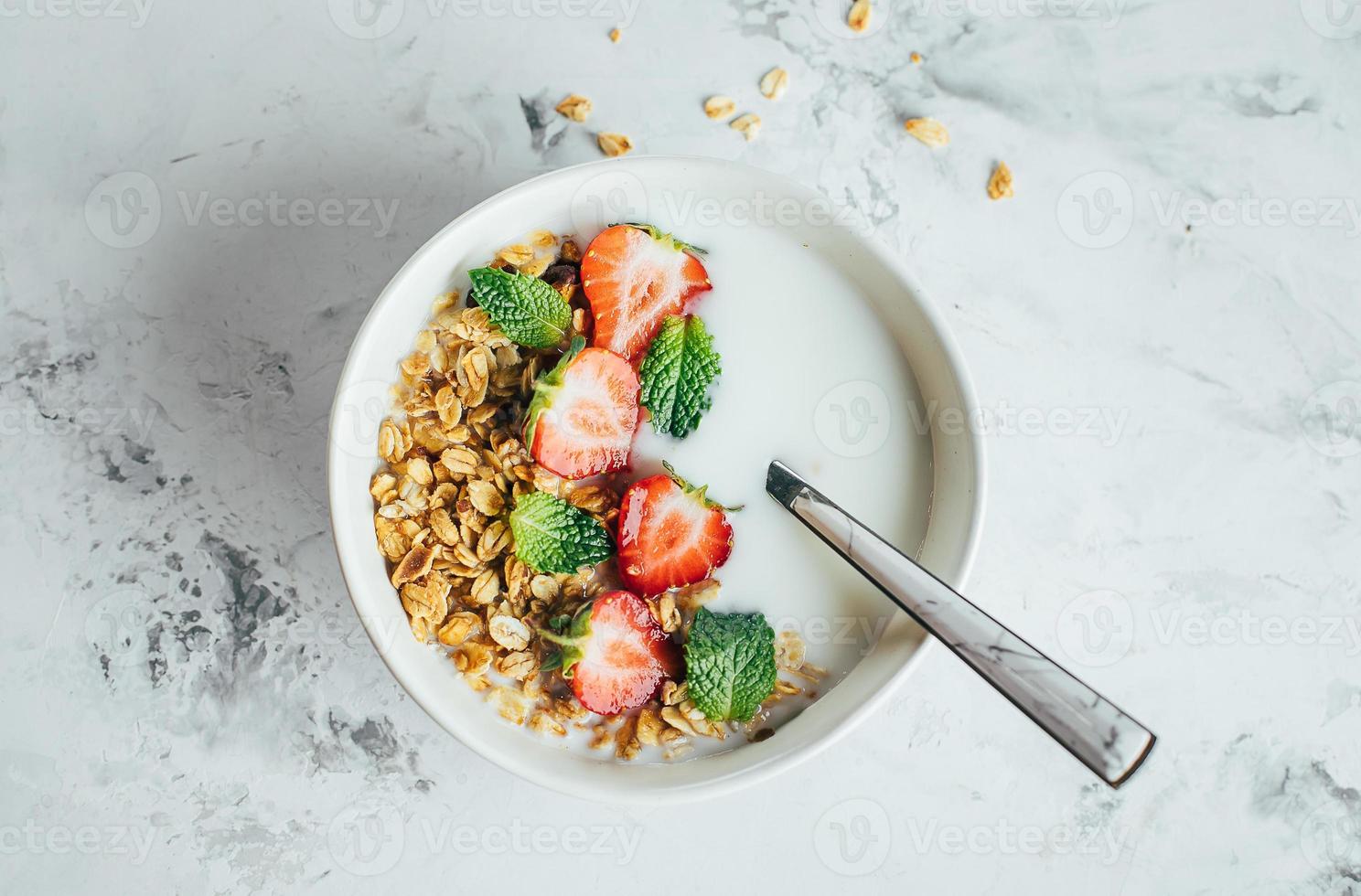 salutare prima colazione concetto. ciotola con muesli, Yogurt e frutti di bosco su bianca marmo sfondo. foto