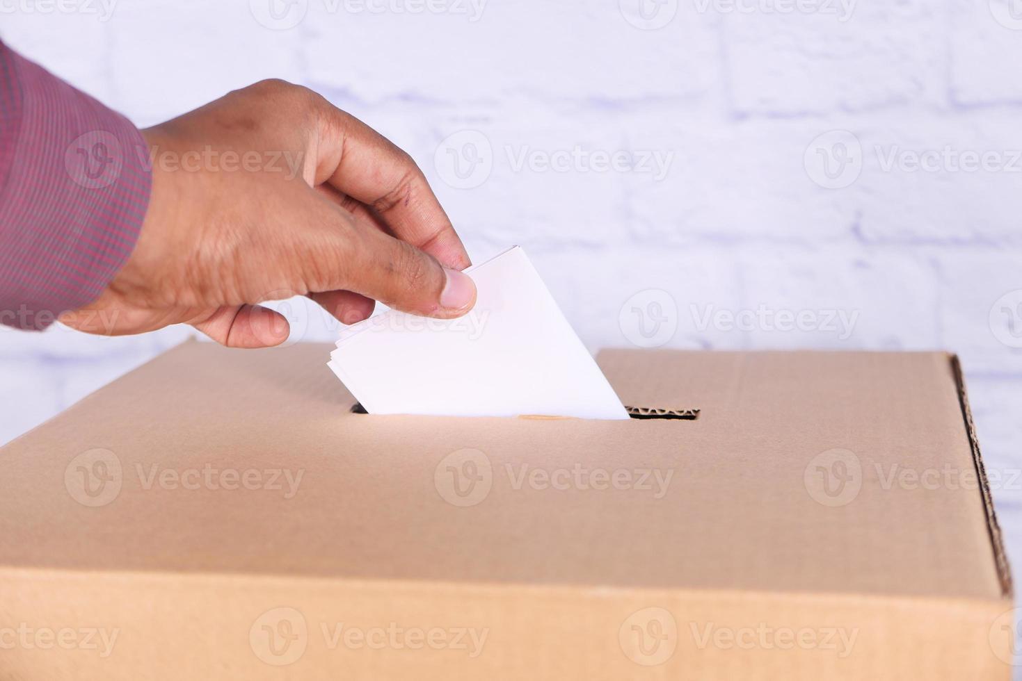 stretta di mano d'uomo mettendo la carta in una scatola con slot foto