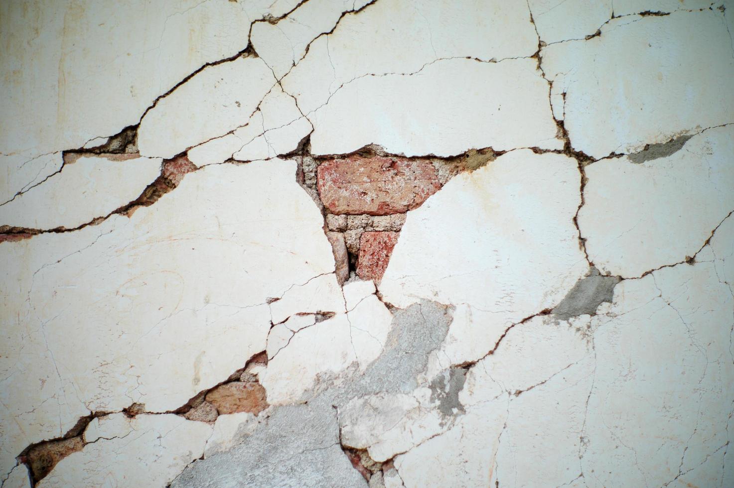 sfondo astratto e la consistenza del muro di cemento rotto con strati di mattoni all'interno foto