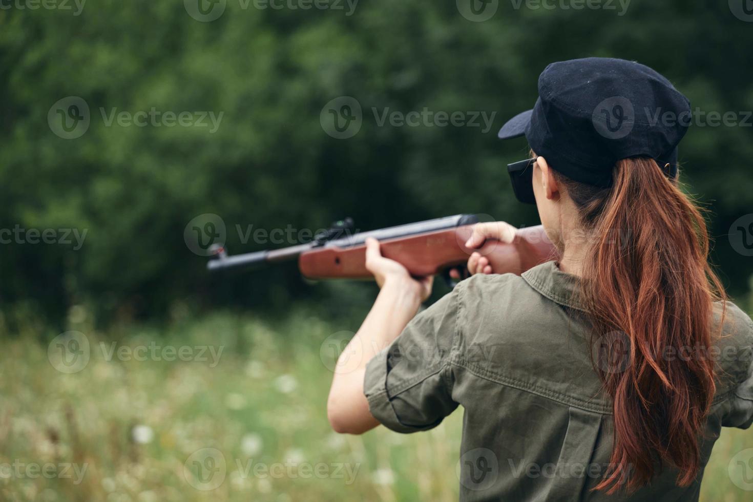 militare donna Tenere un' pistola a caccia bersaglio posteriore Visualizza verde tuta da lavoro foto