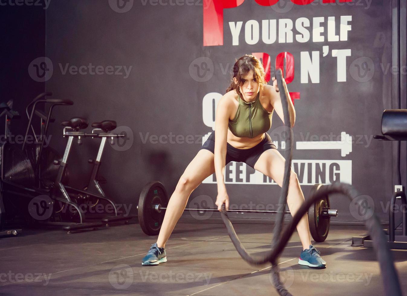 giovane donna sottile corpo formazione e Lavorando su con battaglia corda a fitness Palestra foto