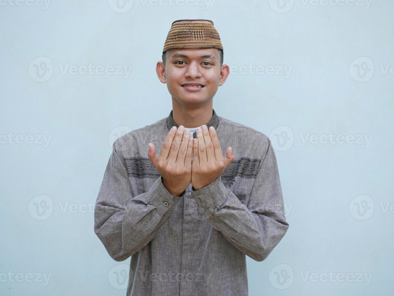ritratto di giovane asiatico musulmano uomo raccolta mani nel preghiera foto
