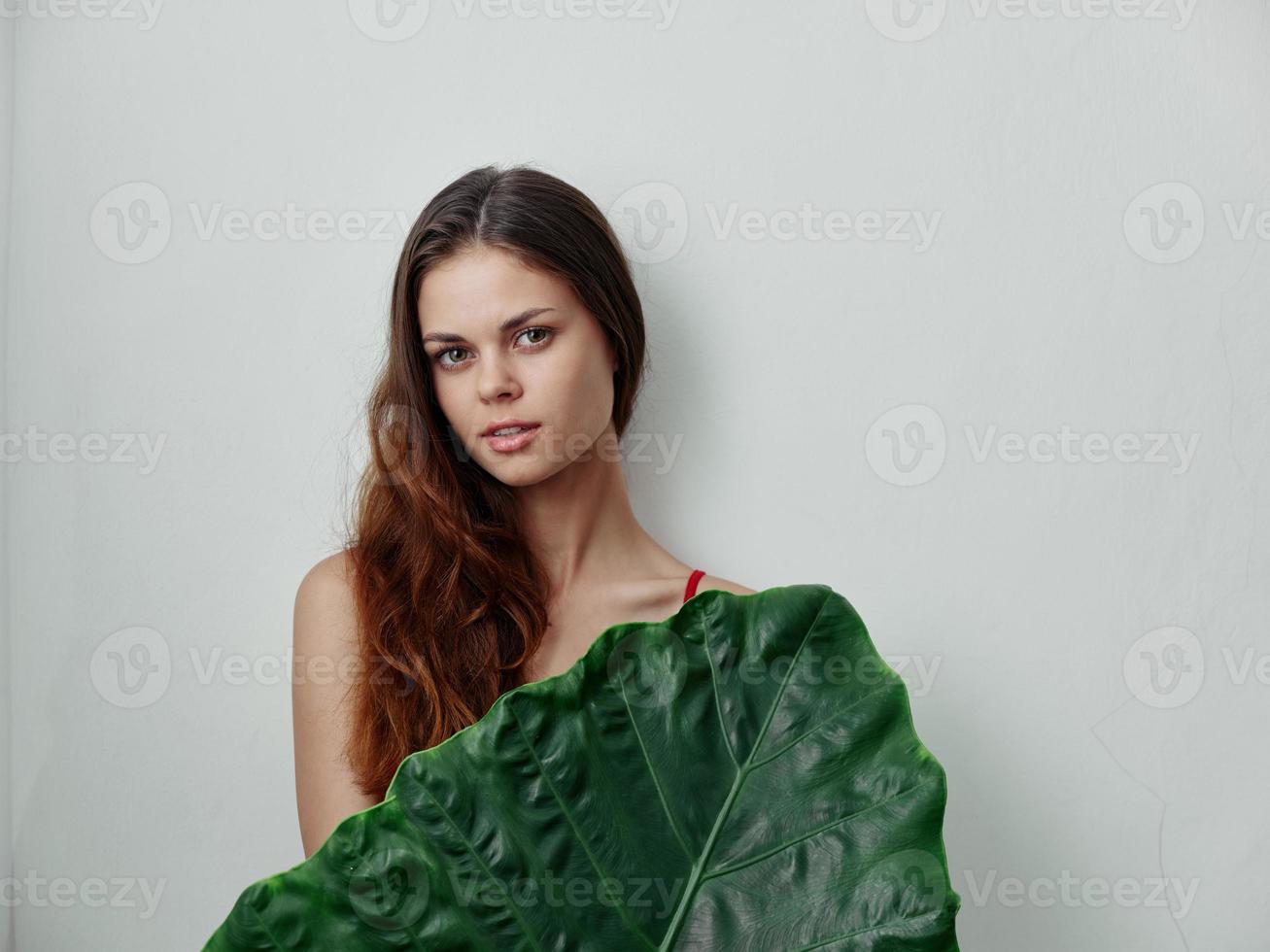 donna con spoglio le spalle rosso capelli verde palma foglia leggero sfondo foto