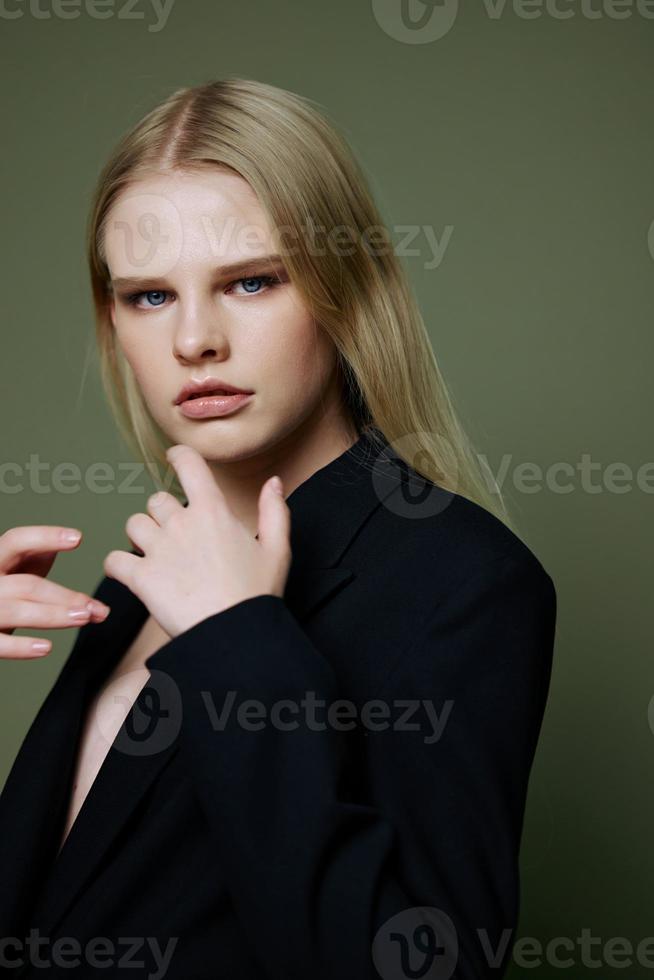 un' vicino ritratto di un' bellissimo ragazza in posa nel un' studio su un' verde sfondo foto