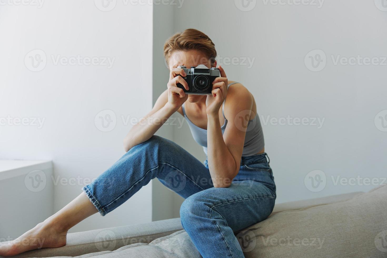 donna fotografo tiro nel studio su vecchio film telecamera a casa su divano ritratto, bianca sfondo, gratuito copia spazio, libero professionista fotografo foto