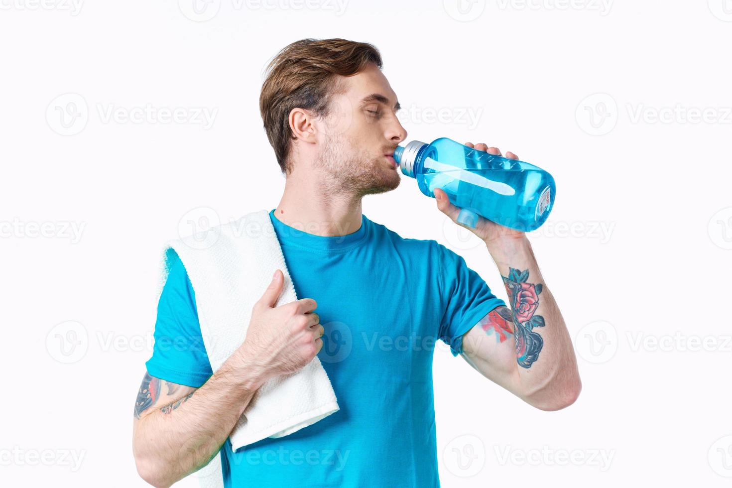 gli sport tipo nel blu maglietta con un' bottiglia di acqua nel il fiume e tatuaggio bianca sfondo fitness modello foto