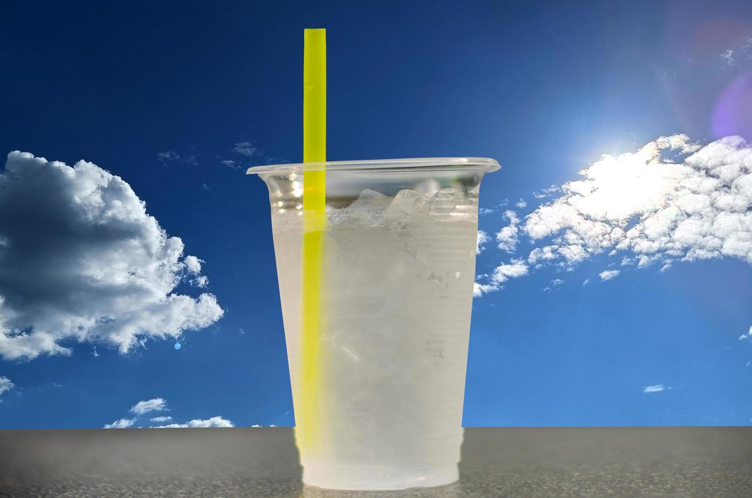 freddo potabile acqua nel un' bicchiere Aiuto impedisce calore ictus malattia su luce del sole, cielo e nuvole sfondo foto