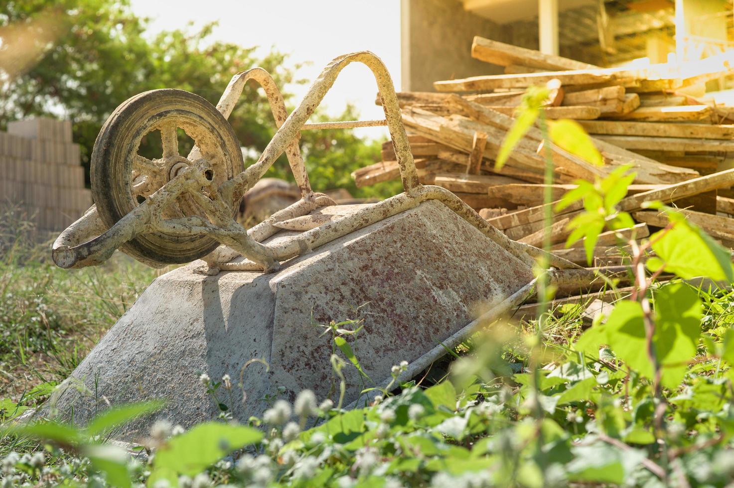 messa a fuoco selettiva sul parcheggio del carrello di cemento in cantiere con catasta di legna da ardere sfocata foto