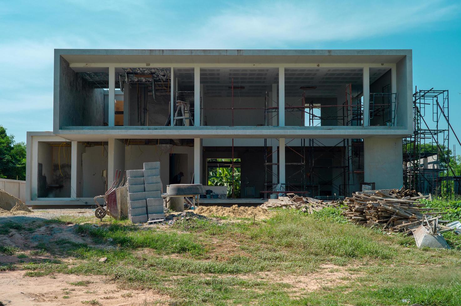 paesaggio e prospettiva della casa in costruzione con pile di materiali e attrezzature con cielo blu chiaro sullo sfondo foto