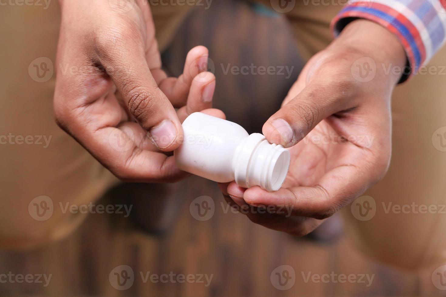 stretta di mano di una persona che tiene il contenitore della pillola foto