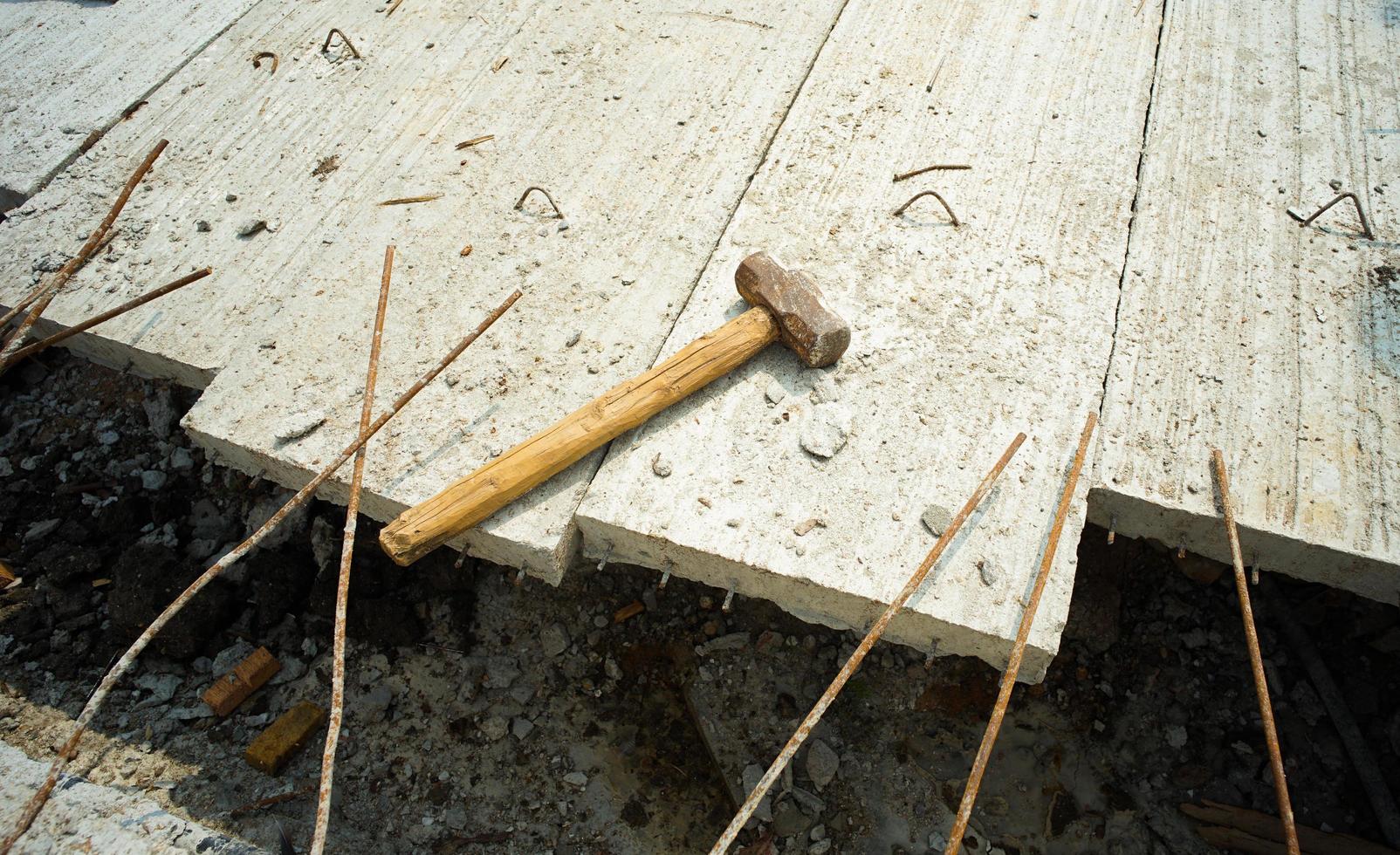 martello mette sull'acciaio di rinforzo del pavimento in cemento foto