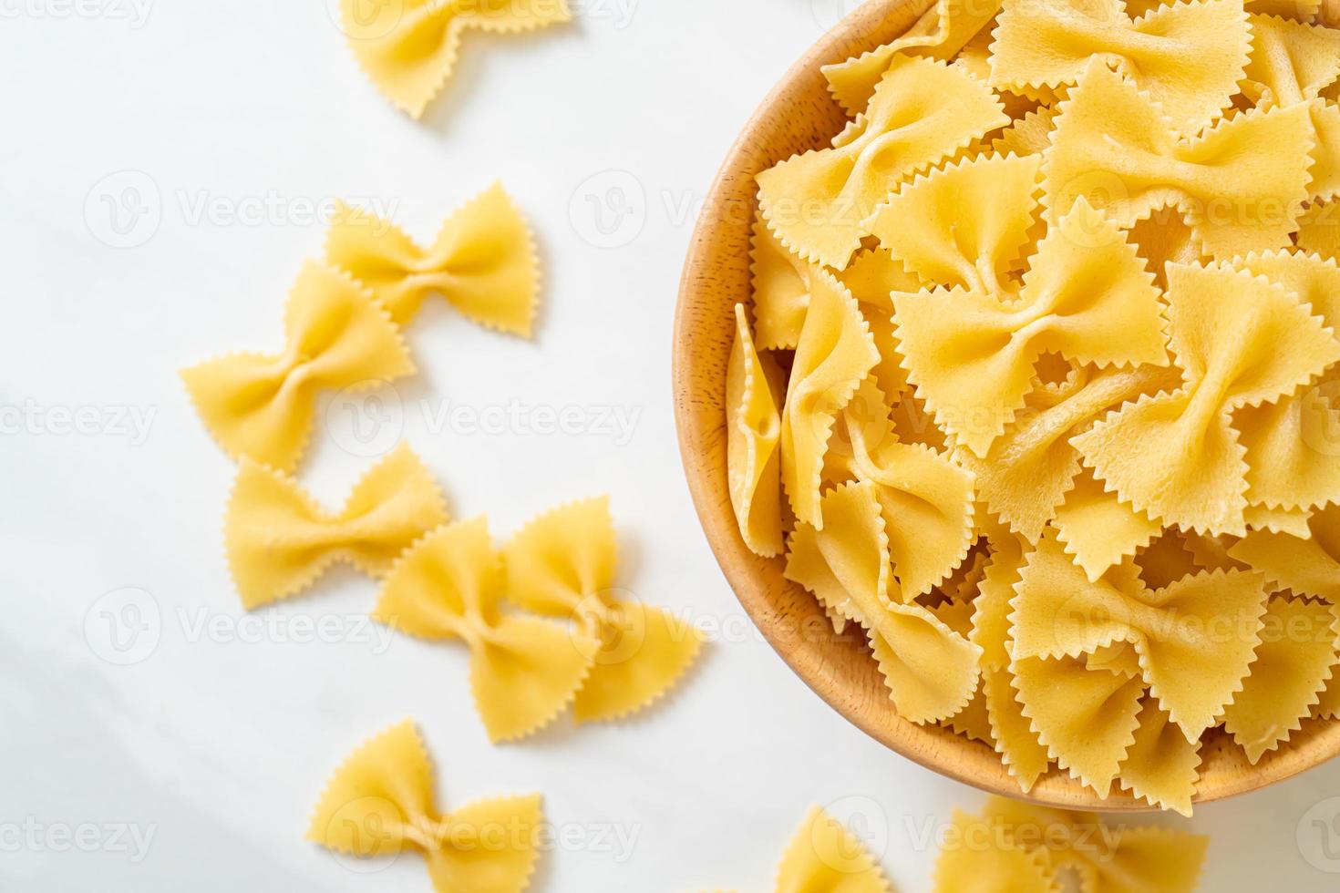 pasta secca di farfalle crude in una ciotola foto