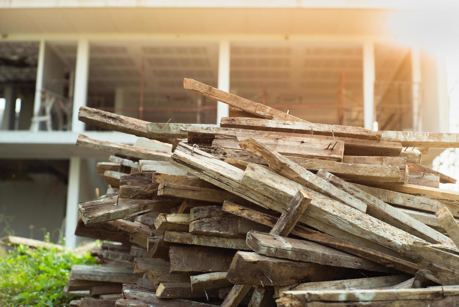 closeup mucchio di legno con casa sfocata in costruzione in background foto