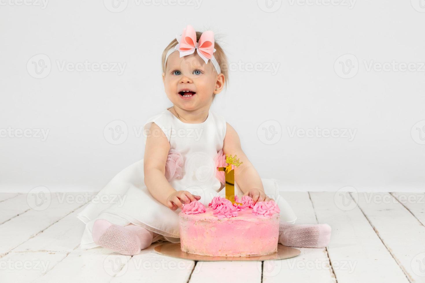allegro poco ragazza con un' festivo torta. bellissimo ragazza uno anno vecchio. foto