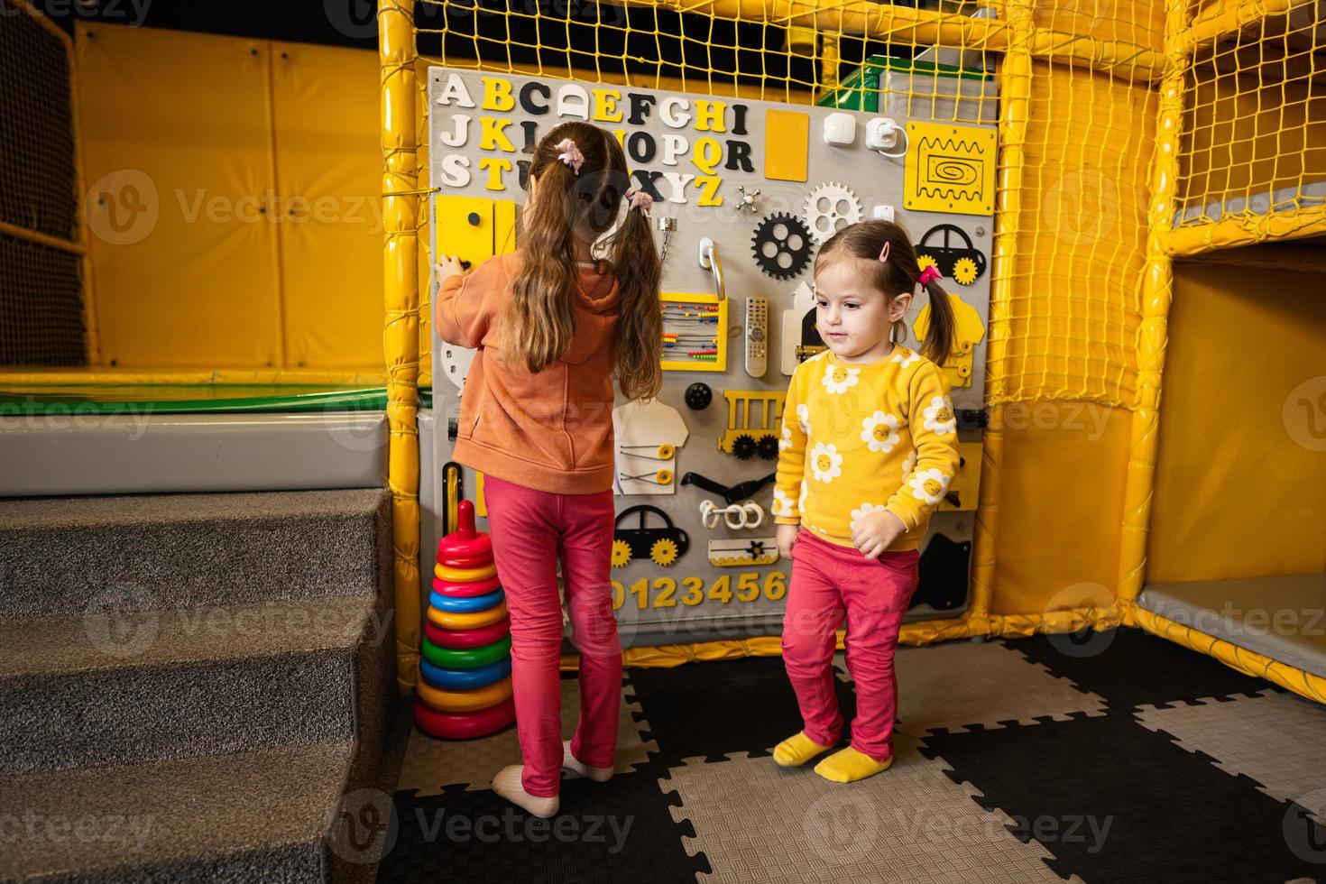 Due sorelle giocando con occupato tavola a bambini giocare centro. foto