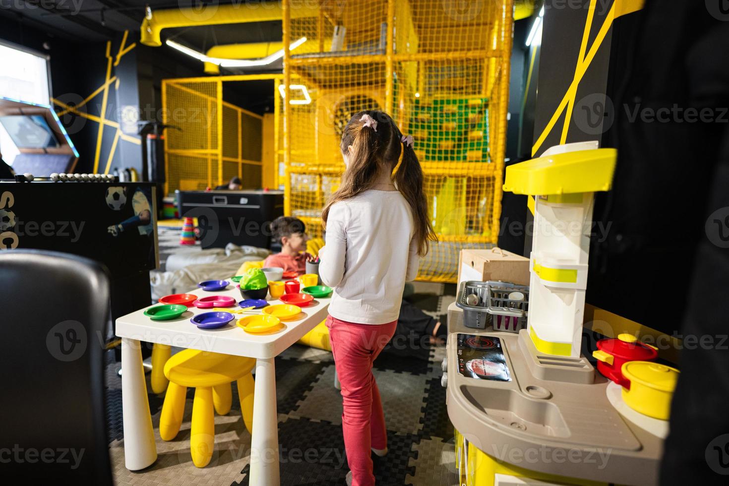 bambino in età prescolare ragazza giocando nel bambini cucina a bambini giocare centro. foto