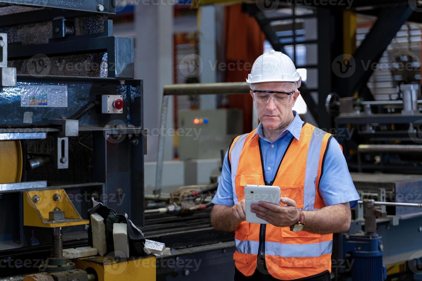 caucasico industriale lavoratore è utilizzando digitale tavoletta per prendere Nota mentre ispezionando dentro il metallo foglio zincato tetto fabbrica per sicurezza industria concetto foto