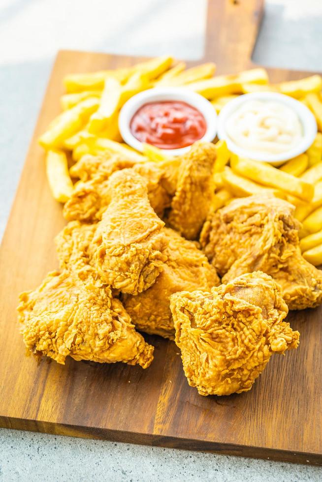 ali di pollo fritte con patatine fritte e salsa di pomodoro o ketchup e maionese foto