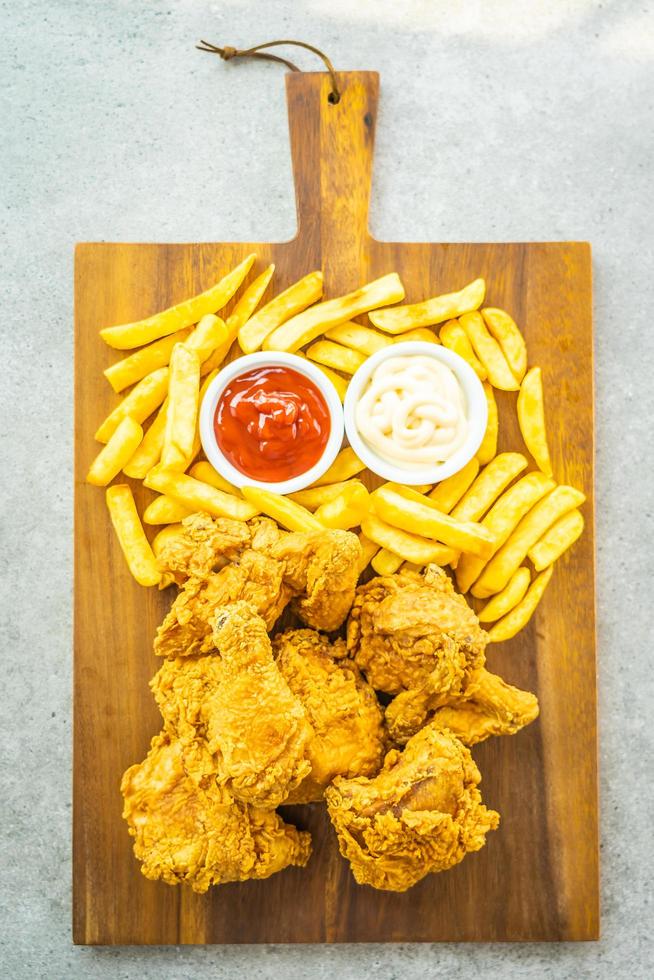 ali di pollo fritte con patatine fritte e salsa di pomodoro o ketchup e maionese foto