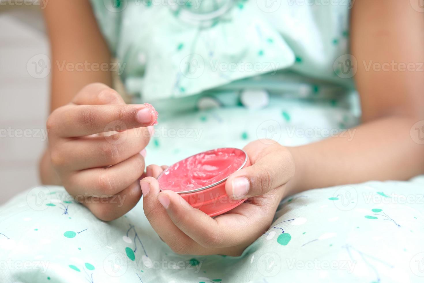 ragazza che utilizza gelatina di petrolio rosa foto