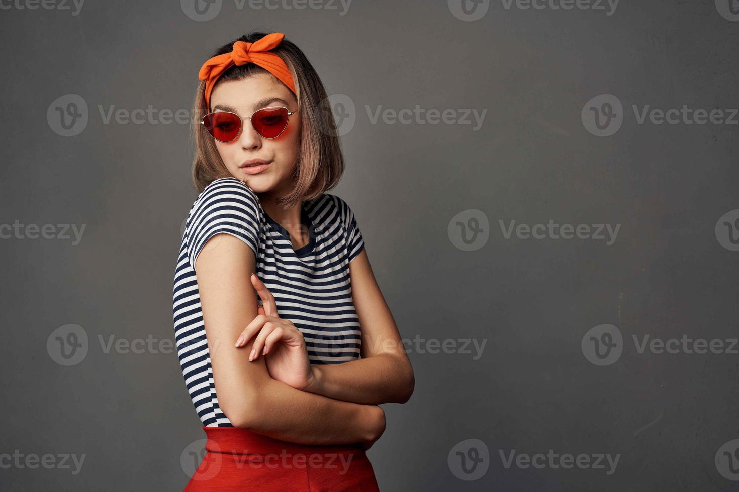 donna con arancia bendare su sua testa indossare occhiali da sole in posa moda lusso foto