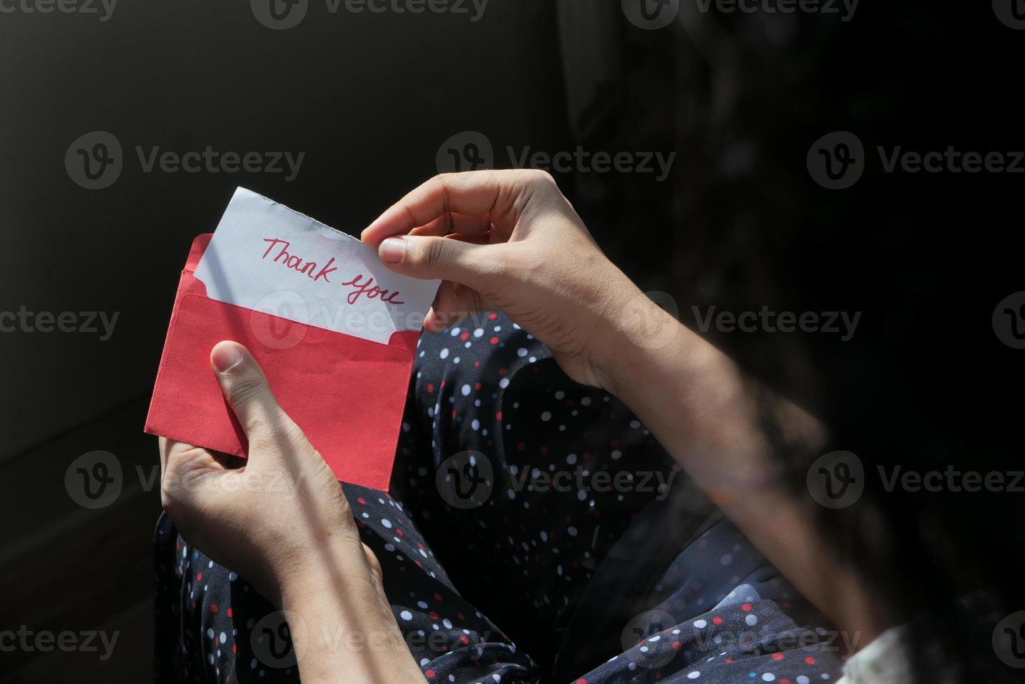 persona che apre un biglietto di ringraziamento foto